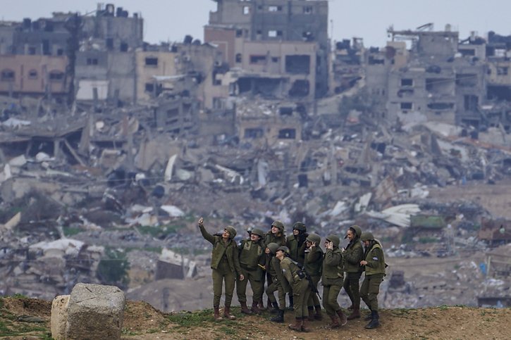 Des soldates de l'armée israélienne se prennent en photo sur sol israélien, à la frontière avec la bande de Gaza. © KEYSTONE/AP/Tsafrir Abayov